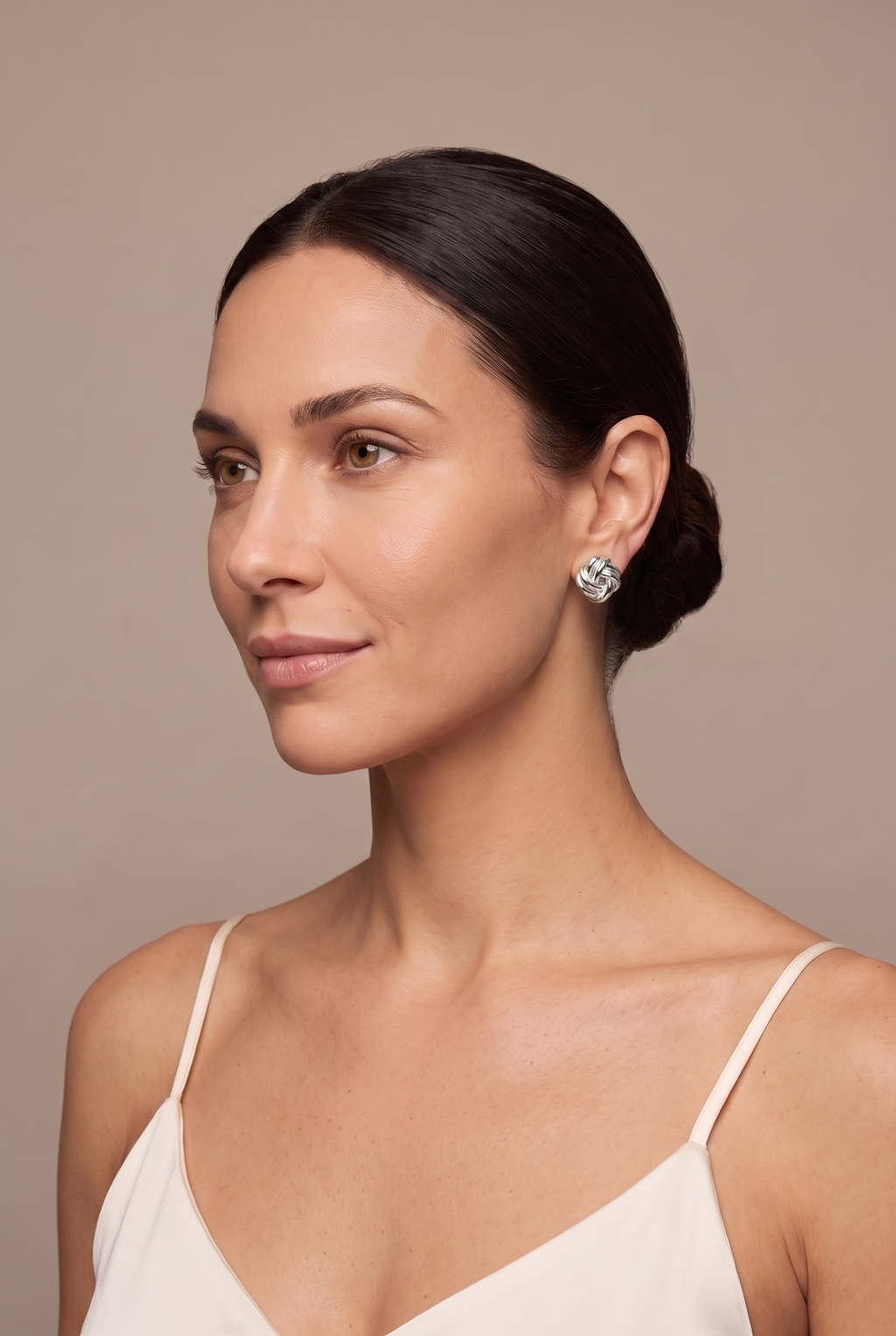 Silver-tone love-knot stud worn on the ear
