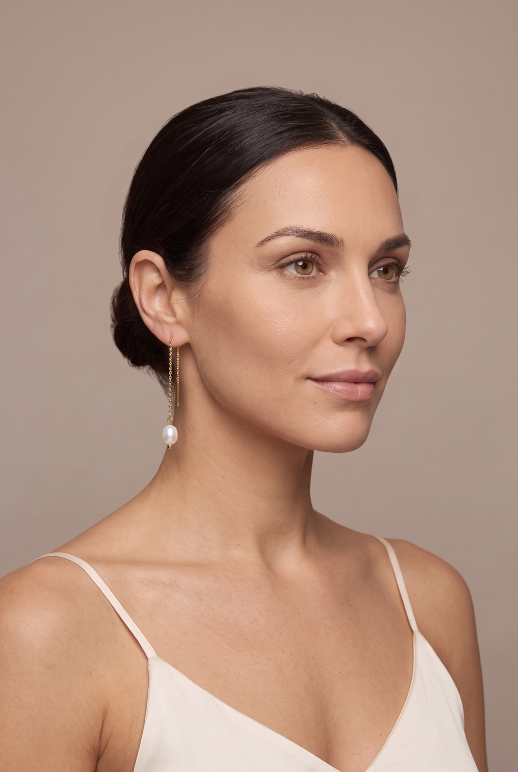 Gold-tone pearl threader earring worn through the ear